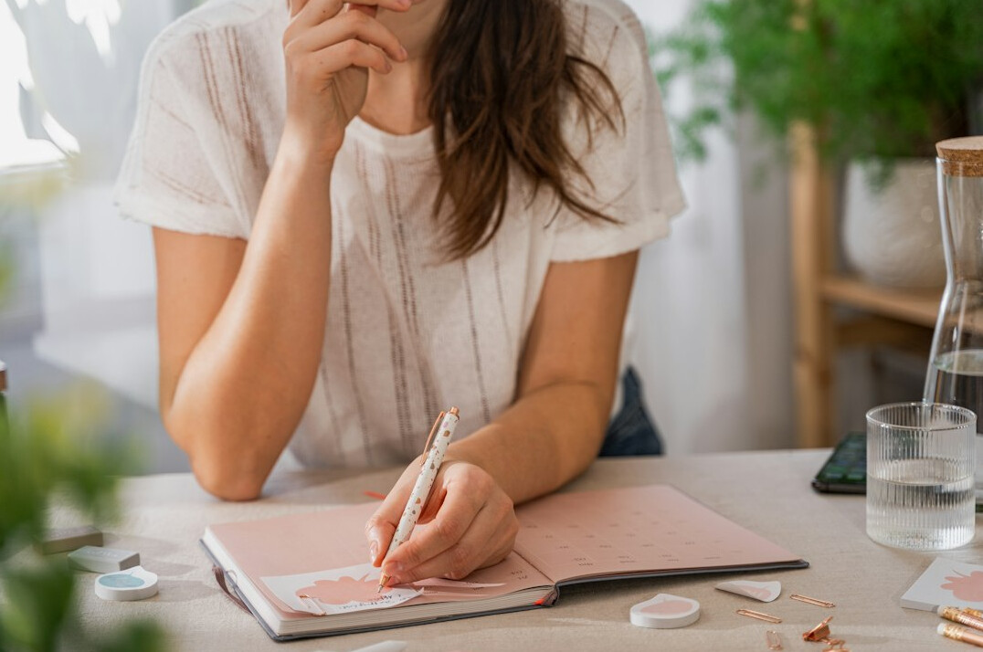 woman writing in journal at home
