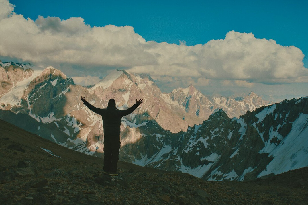 man celebrating success on mountain top